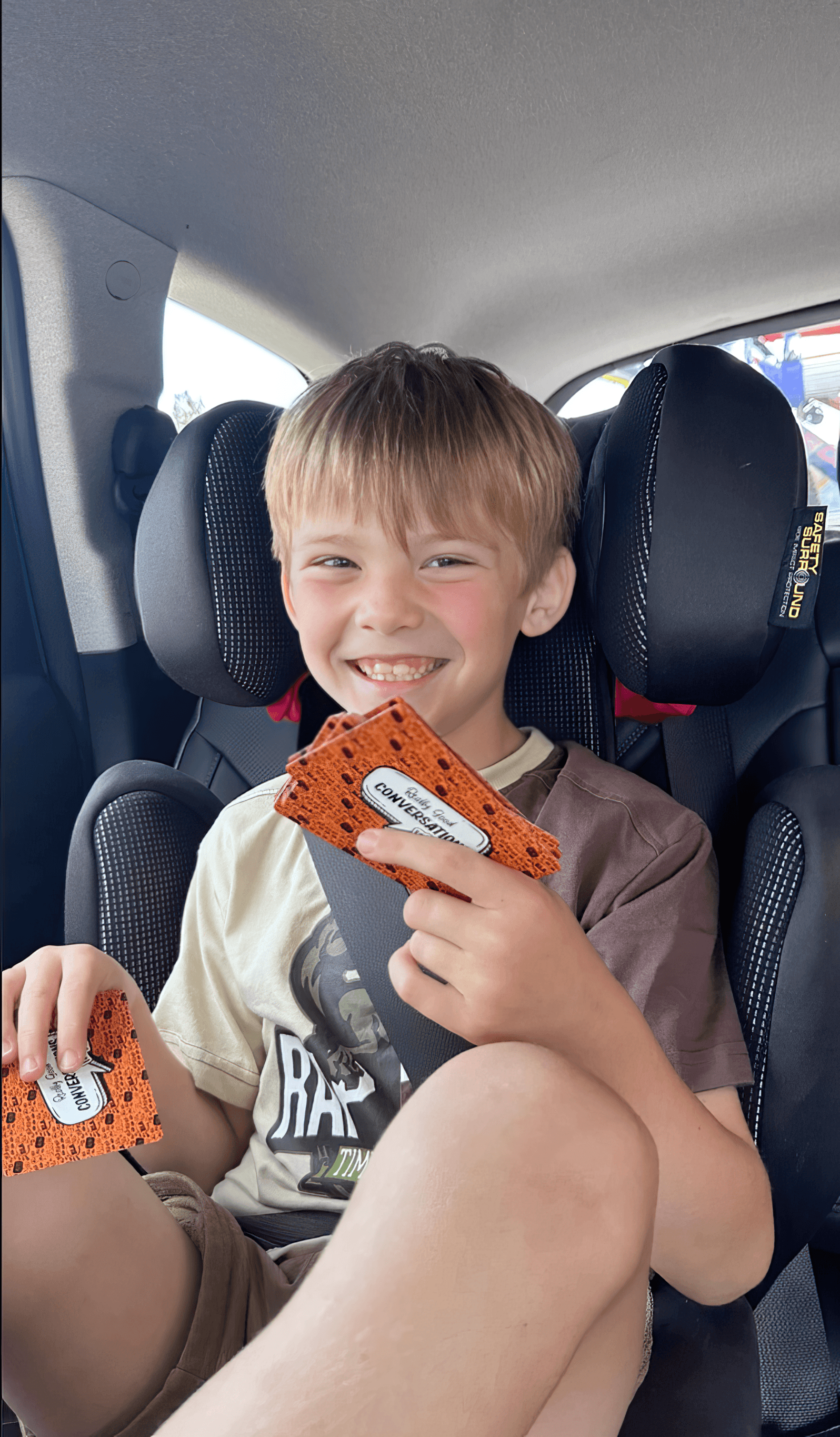 Smiling child playing Really Good Conversations in the car
